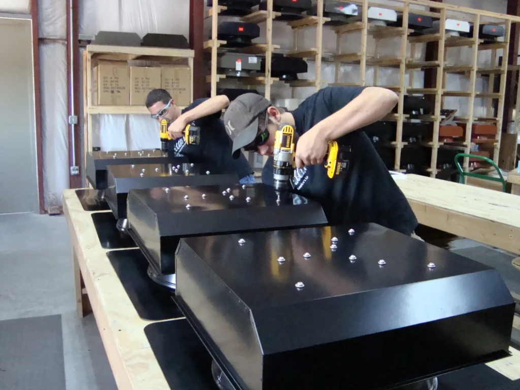 Two Attic Breeze employees assembling solar attic fan housings at the Gatesville, Texas plant
