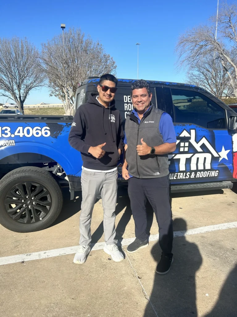 Attic Breeze sales rep and a roofing contractor in front of a TM Metals and Roofing truck