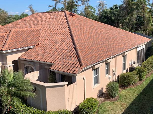 Attic Breeze solar attic fan curb-mounted on a barrel tile roof in Florida