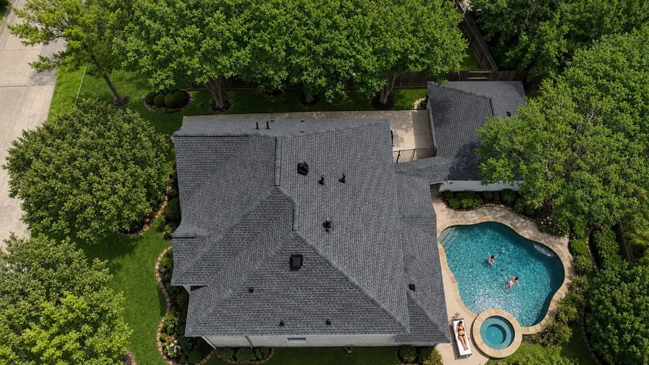 Overhead view of a home with several Attic Breeze solar attic fans installed across the roof
