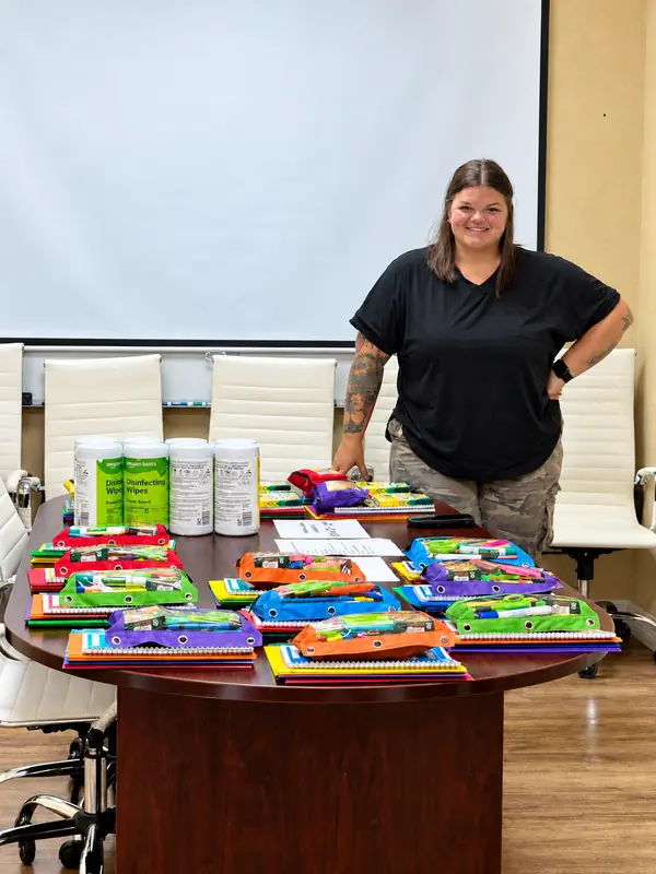 Attic Breeze team member with donated school supplies