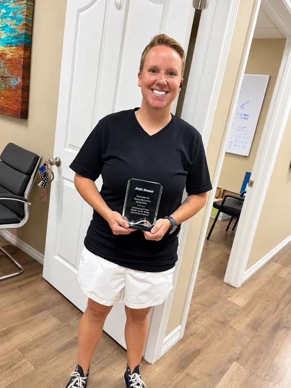 Attic Breeze team member holding a five-year service award